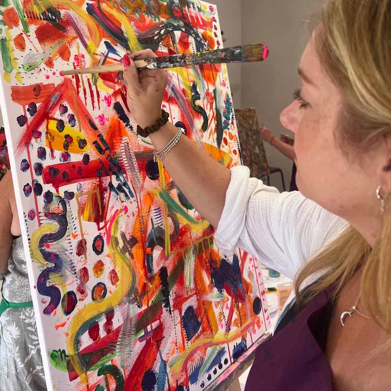 Participant painting during an abstract painting and mixed media workshop in Chichester