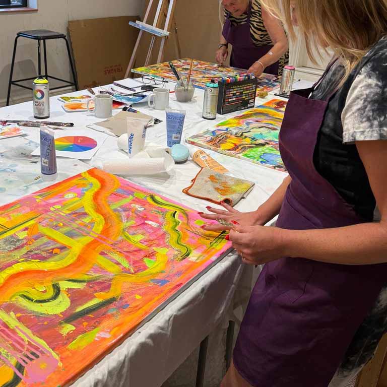 Participant painting during an abstract painting and mixed media workshop in Chichester